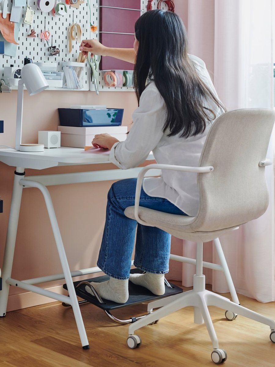 A study desk and chair set against a wall of open shelving
